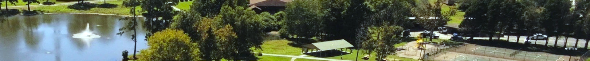 Aerial view of Shamrock Park with its lake, lawn, pavilion, courts and walking paths.