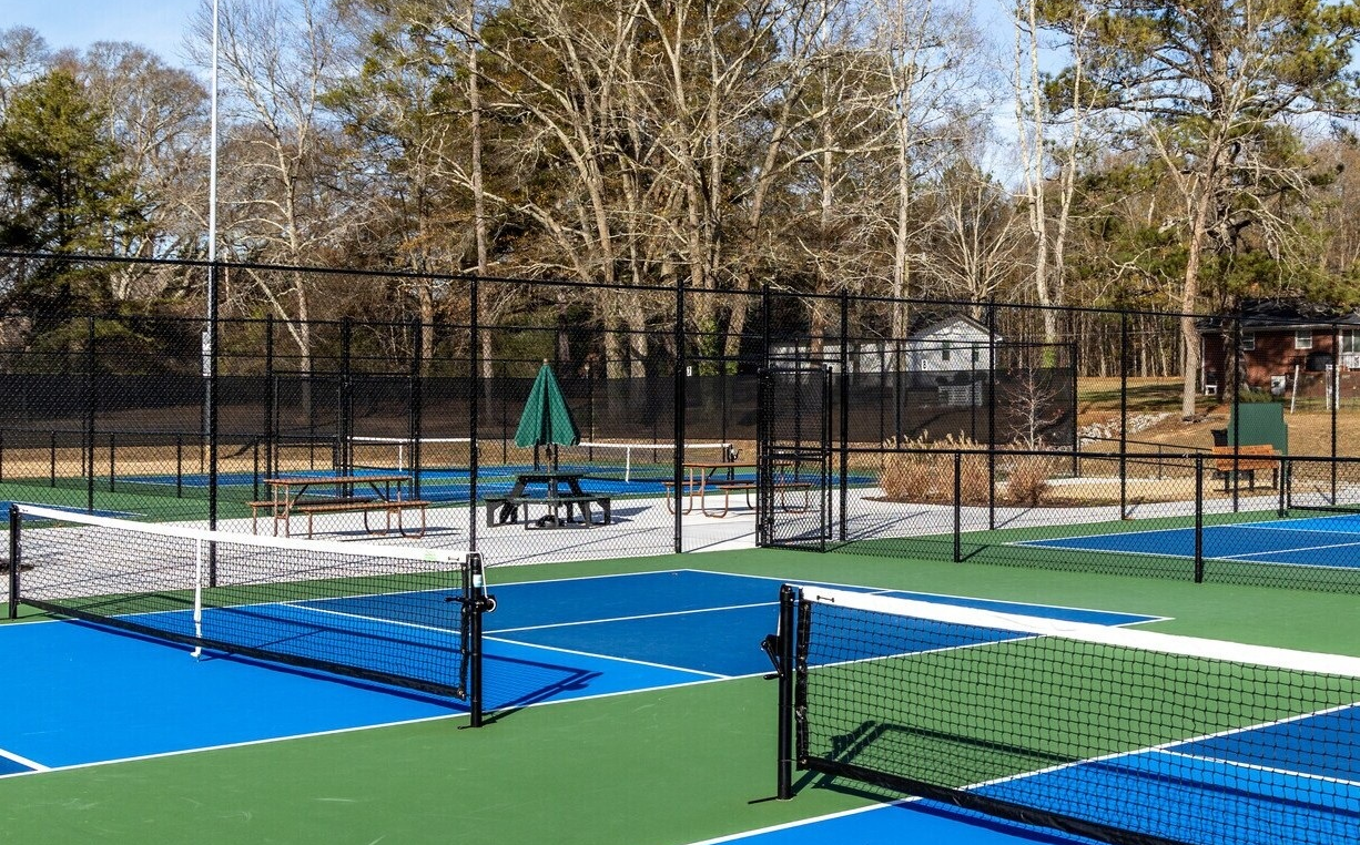 Blue and green pickleball courts with nets at a Tyrone recreation facility.